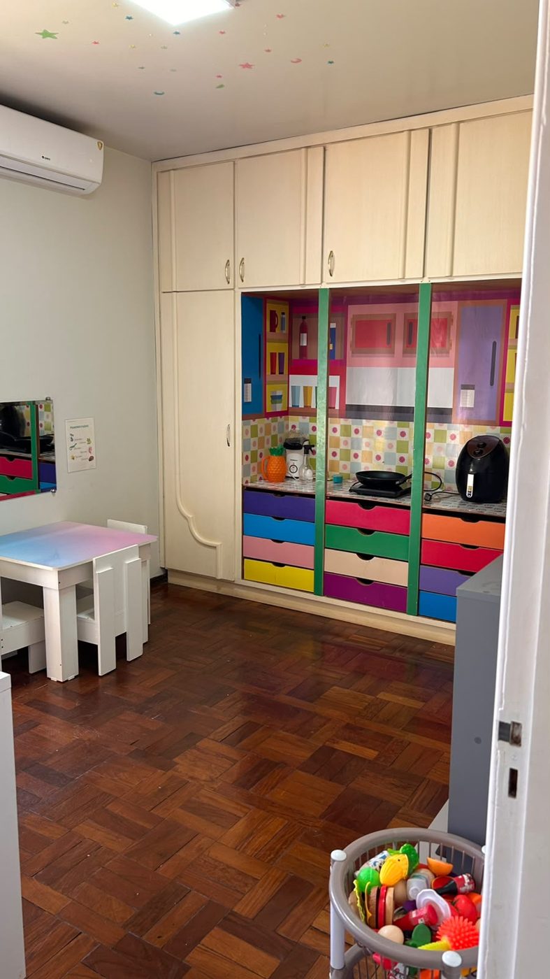 Armário com gavetas coloridas e caixa de brinquedos