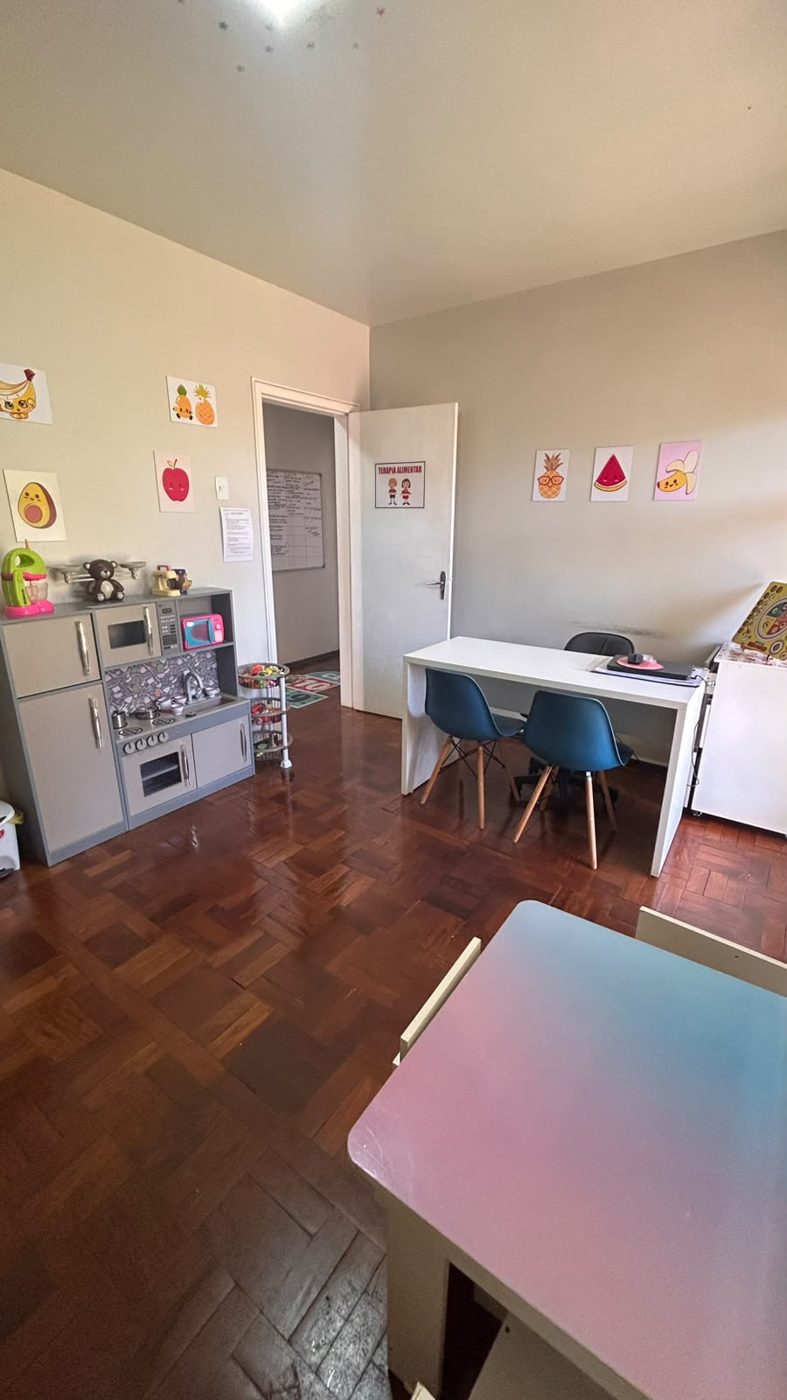 Consultório com mesa de atendimento e cozinha de brinquedo
