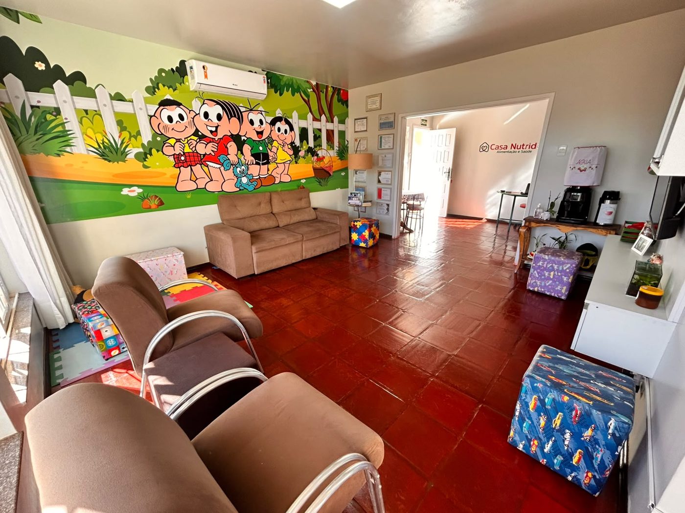 Sala com sofás, tapete e pintura da Turma da Mônica na parede